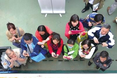 家长在校园开放日拍摄招生资料。京华时报记者徐晓帆摄